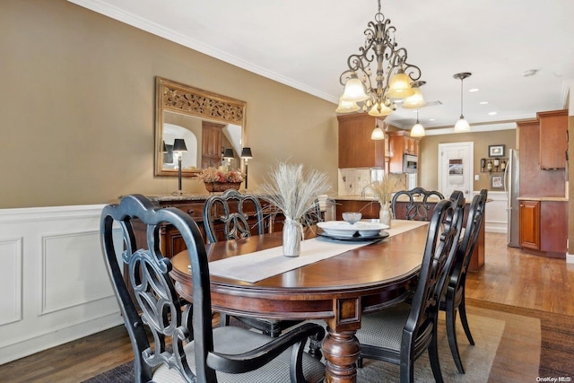 dining area featuring hardwood / wood-style flooring, crown molding, and a chandelier