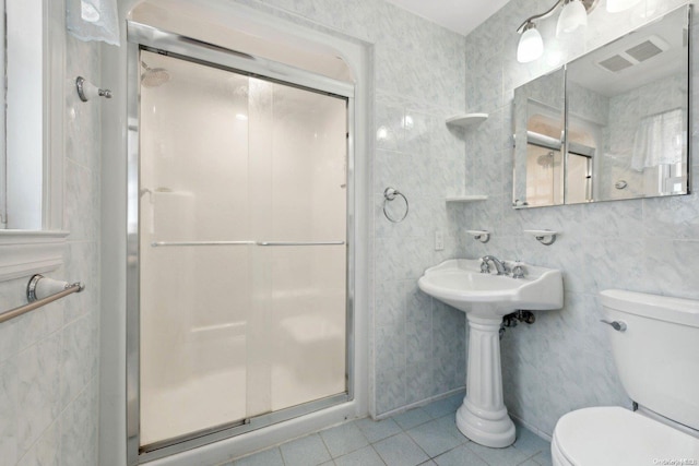 bathroom with tile patterned flooring, an enclosed shower, tile walls, and toilet