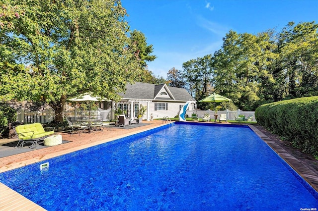 view of swimming pool featuring a patio and a water slide