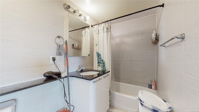 bathroom featuring vanity, tile walls, toilet, and shower / bath combo with shower curtain