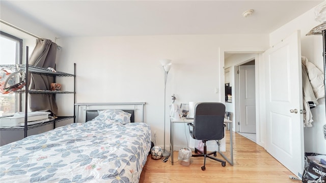 bedroom with multiple windows and wood finished floors