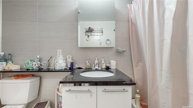 bathroom featuring toilet, curtained shower, and vanity