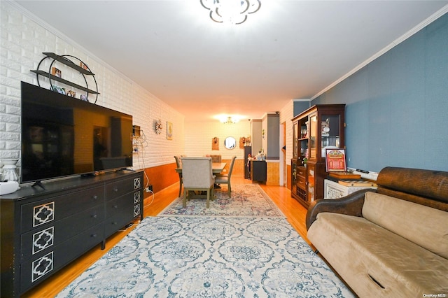 living room featuring hardwood / wood-style floors, brick wall, and ornamental molding