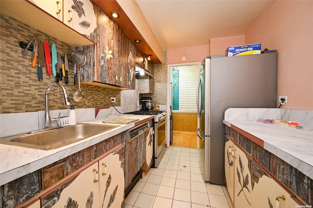 kitchen with stainless steel appliances, light tile patterned flooring, sink, and backsplash