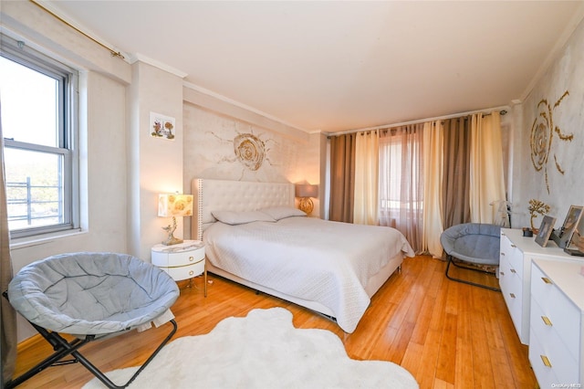 bedroom with crown molding and light hardwood / wood-style floors