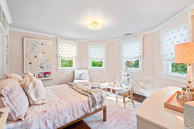 bedroom featuring hardwood / wood-style flooring, crown molding, and multiple windows