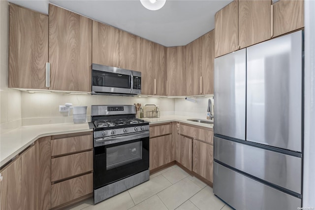 kitchen with sink, light tile patterned floors, and stainless steel appliances