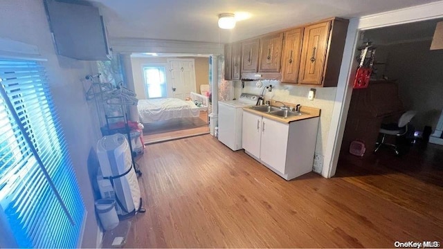 kitchen with light hardwood / wood-style floors, sink, and washer / clothes dryer