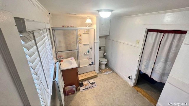 full bathroom with tile patterned floors, crown molding, bath / shower combo with glass door, toilet, and vanity