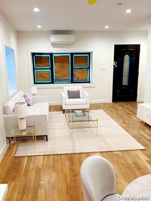 living room featuring hardwood / wood-style floors and a wall mounted AC