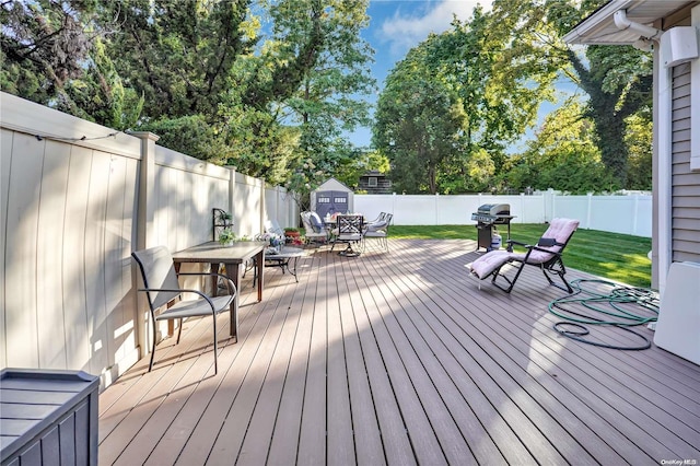 wooden deck with a storage unit and grilling area