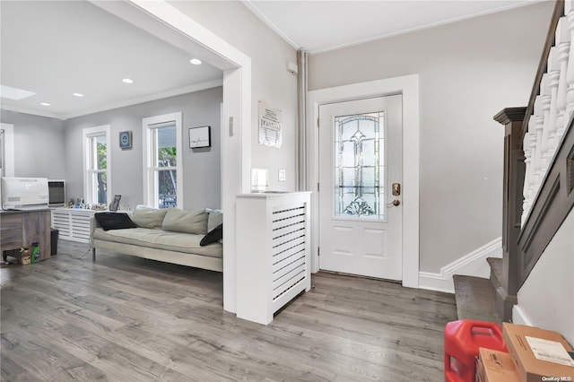 entryway with light hardwood / wood-style flooring and ornamental molding