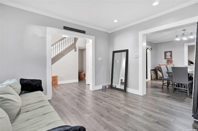 living room featuring a chandelier, wood-type flooring, and crown molding