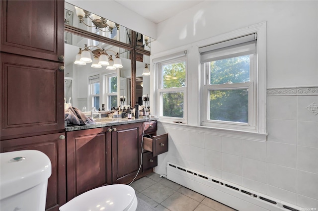 bathroom featuring vanity, a baseboard heating unit, tile patterned floors, toilet, and tile walls