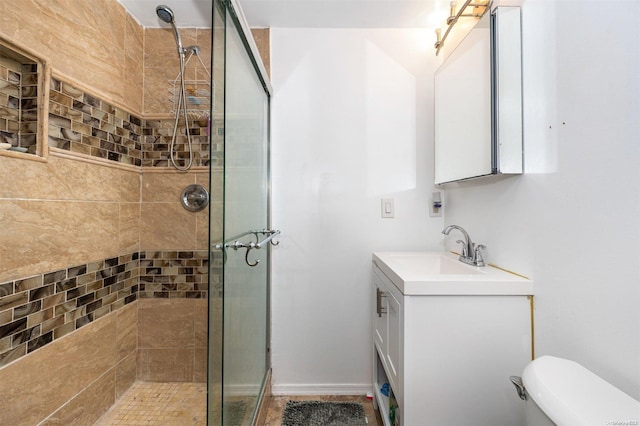 bathroom with vanity, toilet, and a shower with door