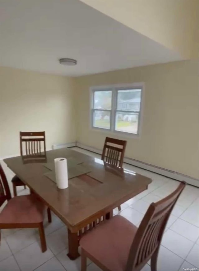 dining space featuring light tile patterned floors and a baseboard heating unit