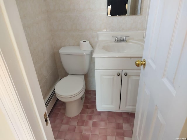 bathroom featuring tile patterned floors, vanity, a baseboard heating unit, tile walls, and toilet