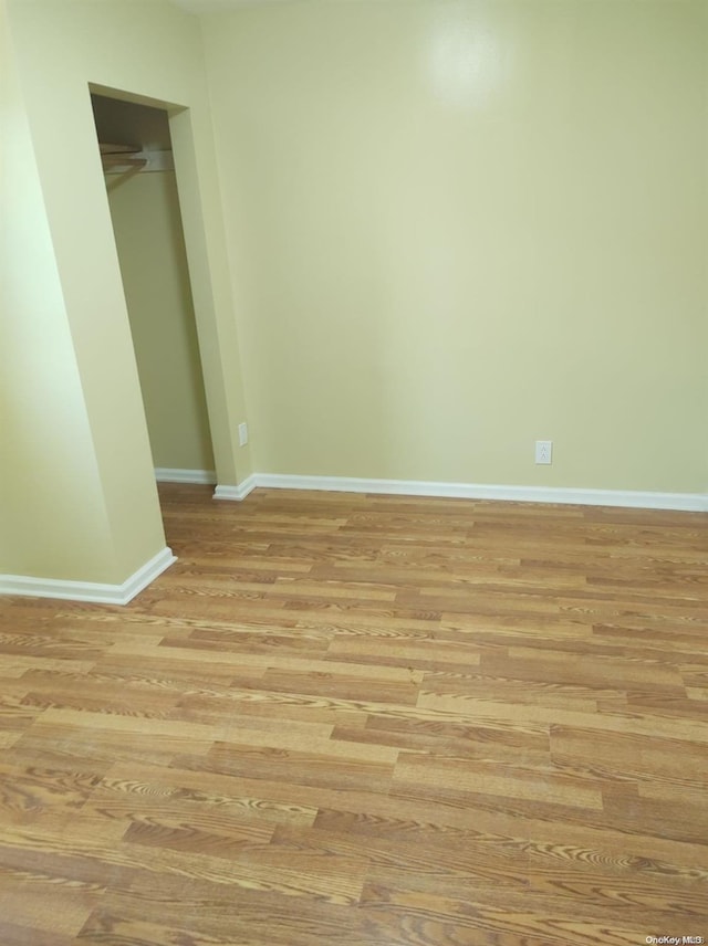 unfurnished bedroom with light wood-type flooring and a closet