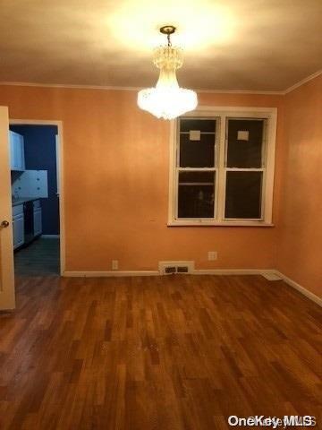 unfurnished dining area with dark hardwood / wood-style flooring and ornamental molding