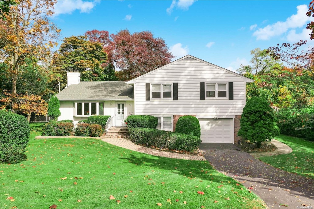 split level home with a front yard and a garage