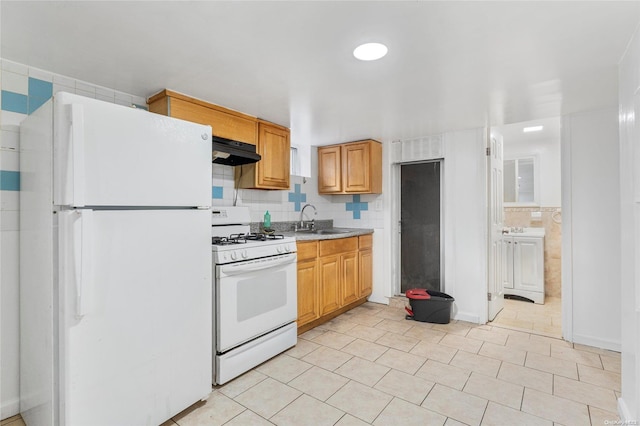 kitchen with decorative backsplash, white appliances, and sink