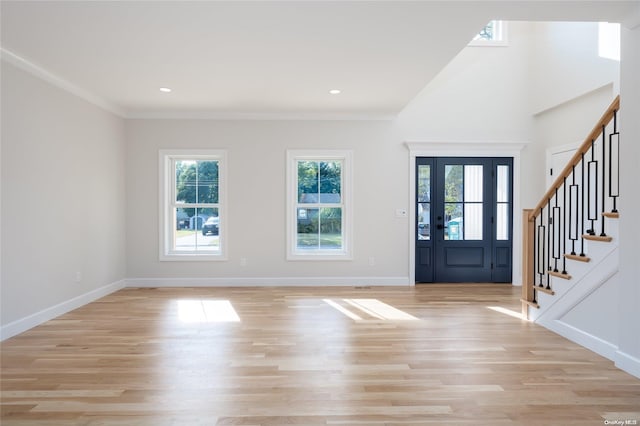 foyer with light hardwood / wood-style floors and crown molding