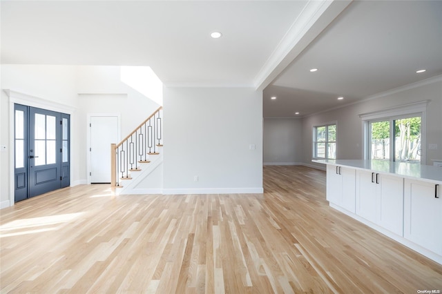 foyer featuring beamed ceiling, light hardwood / wood-style floors, and ornamental molding