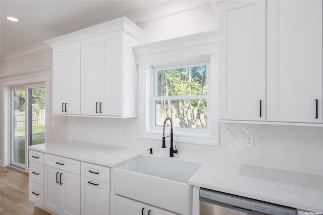 kitchen featuring stainless steel dishwasher, white cabinets, sink, and a wealth of natural light