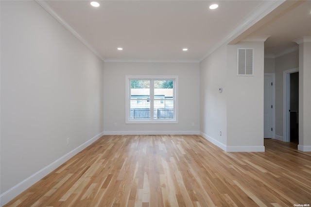 empty room with light hardwood / wood-style floors and crown molding