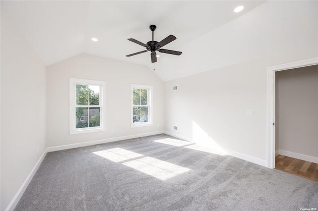 carpeted spare room with vaulted ceiling and ceiling fan