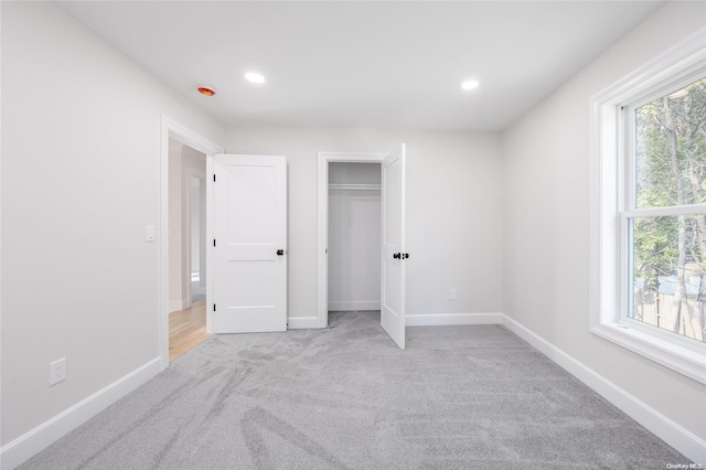 unfurnished bedroom with multiple windows and light colored carpet