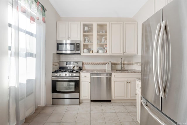 kitchen featuring sink, white cabinetry, stainless steel appliances, and light tile patterned floors