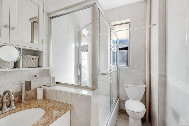 bathroom with toilet, vanity, tile walls, and walk in shower