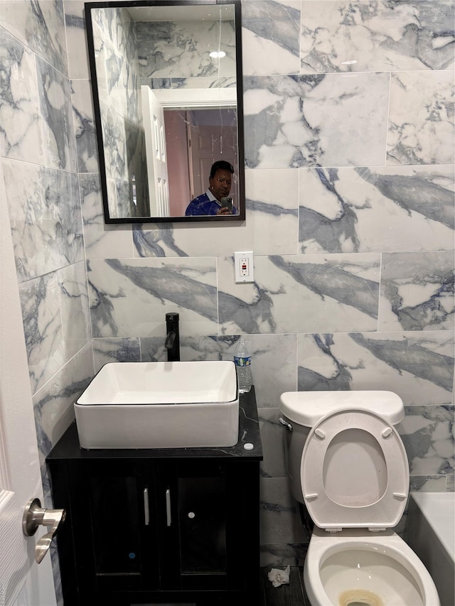 bathroom with vanity, tile walls, and toilet