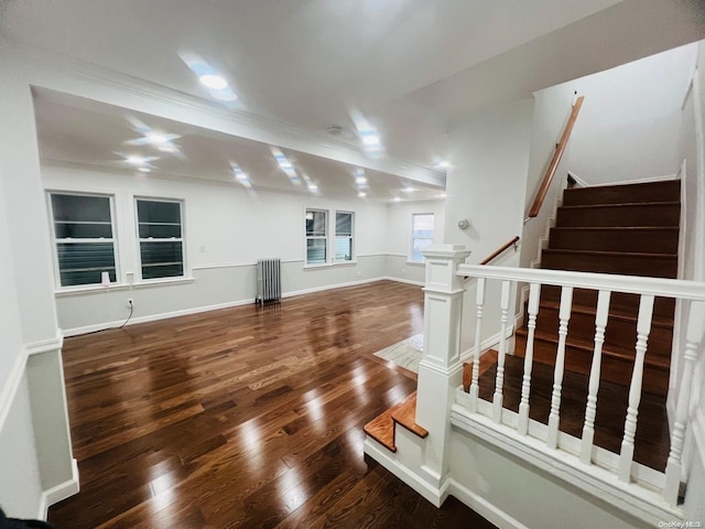 unfurnished living room with crown molding, hardwood / wood-style floors, and radiator heating unit