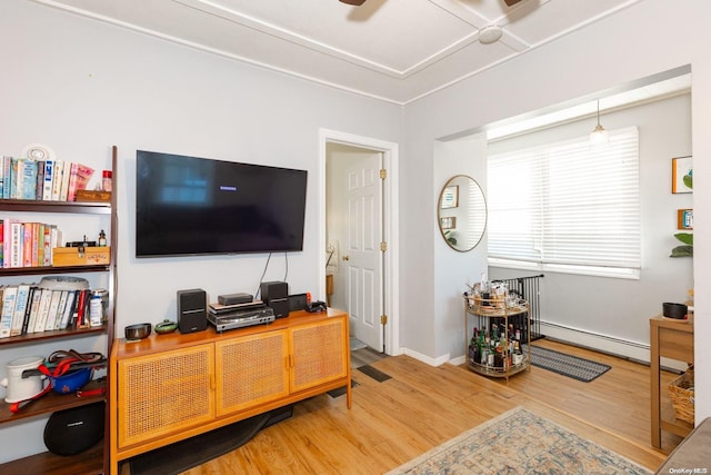 living room with baseboard heating, ceiling fan, and wood-type flooring