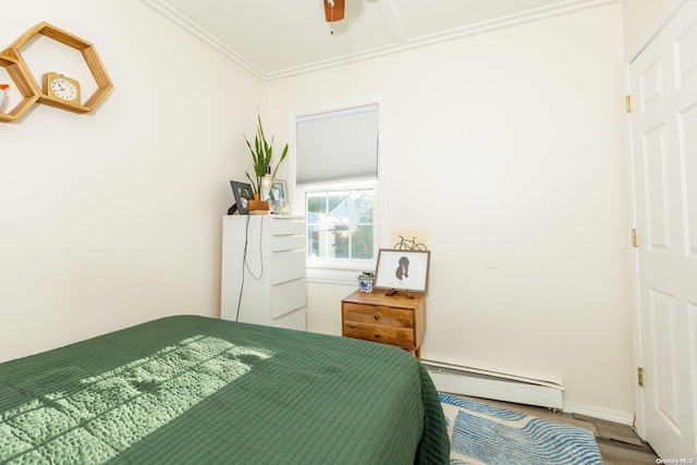 bedroom featuring hardwood / wood-style floors, ornamental molding, ceiling fan, and a baseboard heating unit