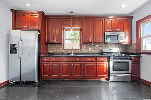 kitchen with decorative backsplash, a wealth of natural light, sink, and stainless steel appliances