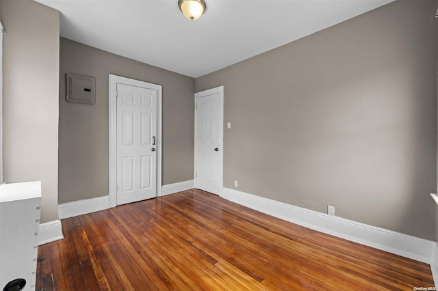 empty room featuring dark hardwood / wood-style floors and electric panel