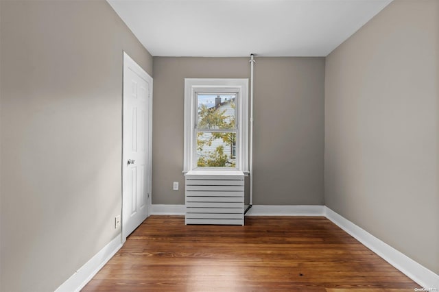 unfurnished room with dark wood-type flooring