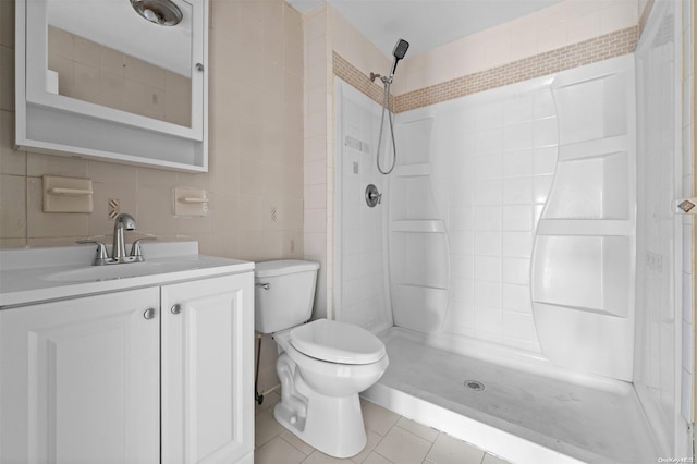 bathroom featuring tile patterned flooring, vanity, toilet, and tile walls