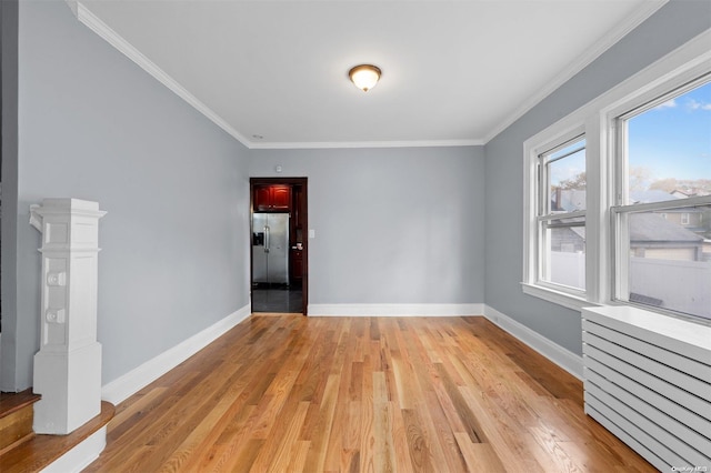 unfurnished room featuring light hardwood / wood-style floors and ornamental molding