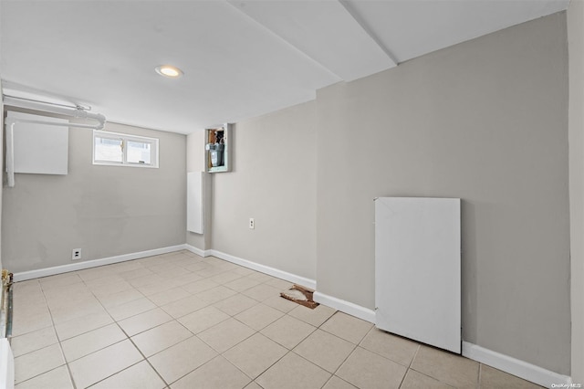 basement with white refrigerator and light tile patterned floors