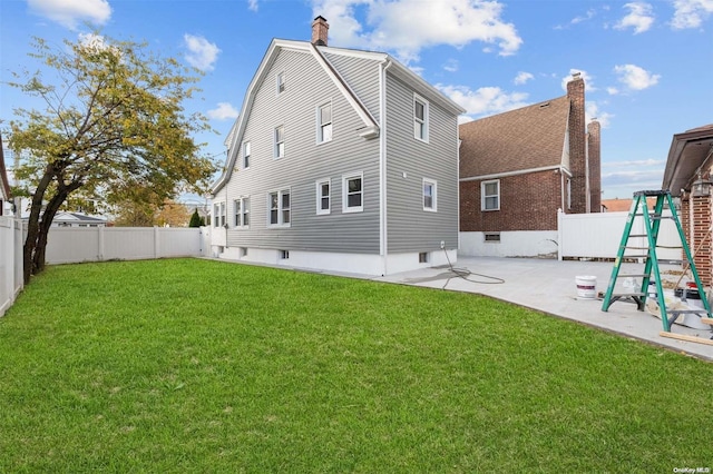 rear view of house with a lawn and a patio area