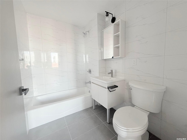 full bathroom featuring tiled shower / bath combo, tile patterned flooring, toilet, vanity, and tile walls