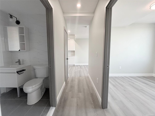 bathroom with hardwood / wood-style floors, vanity, toilet, and tile walls