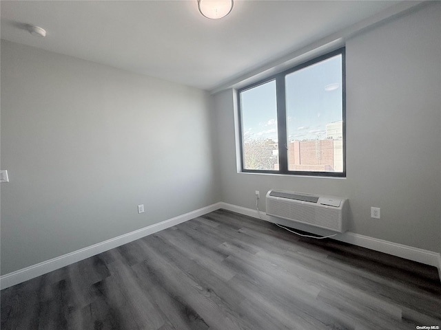 spare room with hardwood / wood-style flooring and an AC wall unit