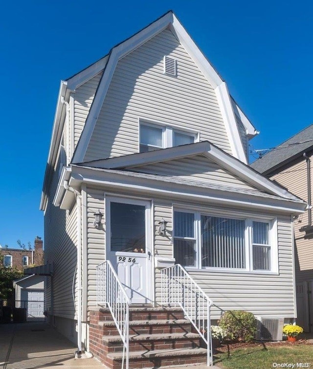 view of front facade featuring an outbuilding, cooling unit, and a garage