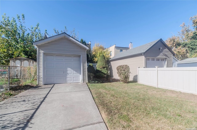 exterior space with a garage, an outbuilding, and a yard