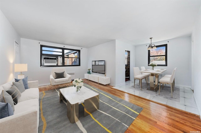 living room featuring hardwood / wood-style flooring, a healthy amount of sunlight, and a chandelier